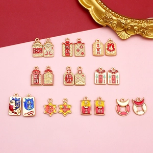 Detail of Chinese style alloy charms with lucky characters and red drip oil finish