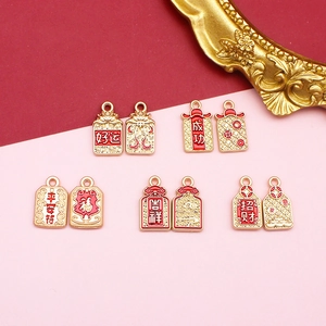 Close-up of gold alloy charms with Chinese auspicious characters for DIY jewelry.