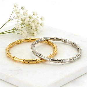 Elegant gold and silver bamboo joint titanium steel bracelets on marble base