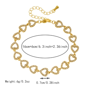 Detail van gouden hartvormige schakelarmband met zirkonia en een karabijnsluiting