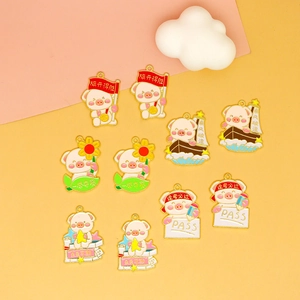 Macro view of colorful enamel pig charms with inspirational themes for DIY jewelry projects.