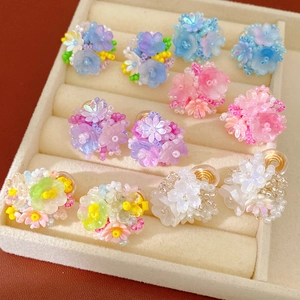 Detailed shot of colorful resin flower beaded clip-on earrings in a jewelry tray