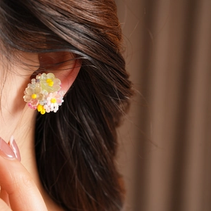 Detailed close-up showing a colorful resin flower beaded ear clip on a female model's ear