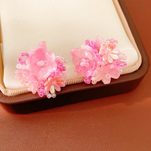 Close-up detail of sweet pink resin flower beaded ear clips presented in a jewelry box