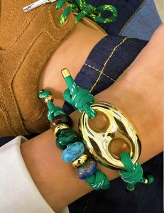Macro detail of handcrafted stone beaded bracelet with vintage gold buckle.