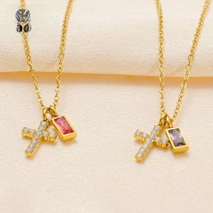 Detail of 18k gold stainless steel necklace with cross and rectangular gem pendants