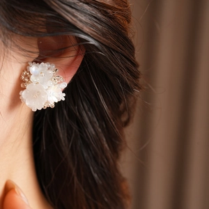 Detailed close-up view of white resin flower beaded ear clips for non-pierced ears