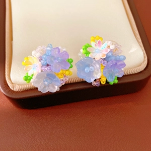 Close-up detail of colorful resin flower beaded clip-on earrings for non-pierced ears