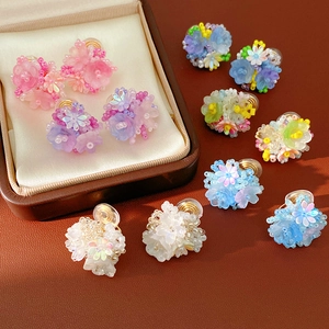 Macro view of colorful resin flower beaded clip-on earrings with intricate details
