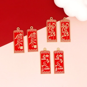Detail of red alloy pendants with gold success blessings for DIY jewelry