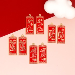 Macro detail of red alloy blessing pendants featuring gold Chinese characters for luck