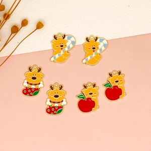 Detail shot of cute enamel Christmas elk and apple charms for DIY jewelry crafting
