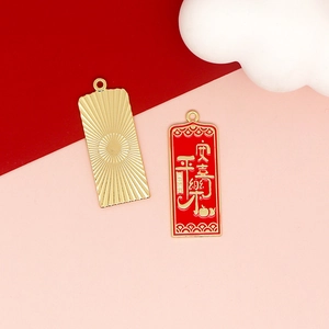 Detailed view of red and gold alloy pendants with Chinese blessing characters for DIY