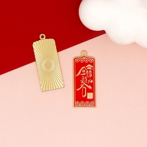 Macro view of red enamel charms with golden blessing characters and sunburst pattern