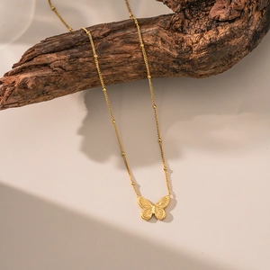 Exquis collier pendentif papillon en or 18 carats sur chaîne satellite sur bois naturel