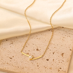 Collier élégant vague dorée avec pendentif perle sur marbre et tissu en soie