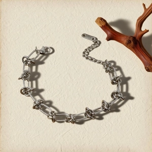 Minimalist silver metal chain bracelet featuring an intricate and stylish knot link design