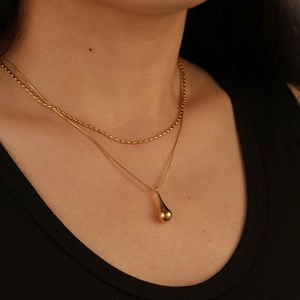 Double-layered gold titanium steel necklace featuring a waterdrop pendant on a snake chain