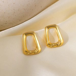 Retro geometric 18k gold plated hollow square earrings on elegant cream silk fabric