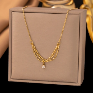Collana di lusso francese in titanio dorato con catena a spiga multistrato e zircone