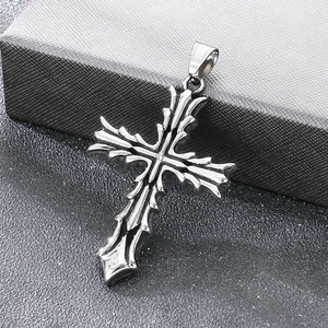 Detalle macro del colgante de cruz de silbato gótico de acero inoxidable para hombre