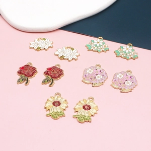 Detailansicht verschiedener Emaille-Blumenanhänger wie Rose und Sonnenblume für DIY.