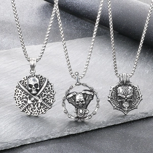 Close-up of three gothic skull pendants featuring pirate and motorcycle engine designs