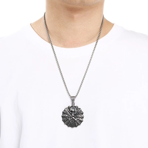 Detail view of a vintage silver skull and crossed swords pendant on a steel chain