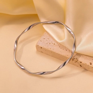 Bracelet jonc Mobius poli en acier titane argenté sur un support en pierre