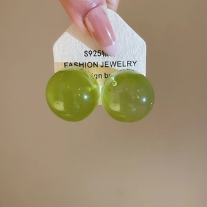 Detailansicht von grünen durchscheinenden Glaskugel-Ohrsteckern mit S925 Silbernadeln