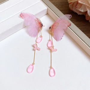 Detail von eleganten rosa Schmetterling Quasten Ohrringen auf einem Schmucktablett.