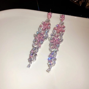 Detailaufnahme der funkelnden rosa Blumen- und Blatt-Quastenohrringe mit hochwertigen Glassteinen