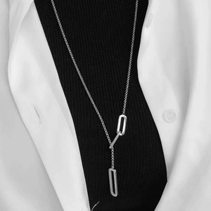 Silver long lariat necklace with rectangular links on model wearing black turtleneck