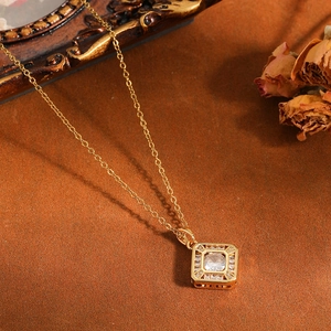 Macrodetail van luxe vierkante hanger met diamanten aan een gouden stalen ketting