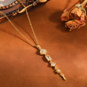 Detailopname van gouden roestvrijstalen ketting met geometrische kristallen bedels