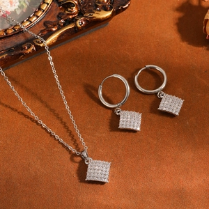 Detail van roestvrijstalen vierkante pavé-ketting met bijpassende oorbellen set.