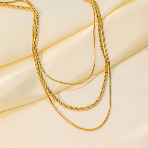 Détails de trois chaînes en plaqué or 18 carats, serpent et corde, sur tissu en soie