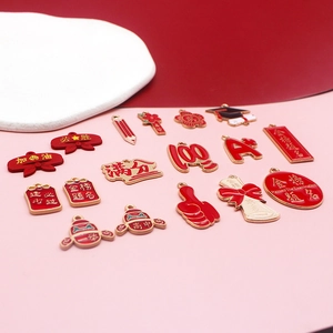 Nahaufnahme von rot-goldenen Emaille-Anhängern zum Thema Abschluss für DIY-Schmuck