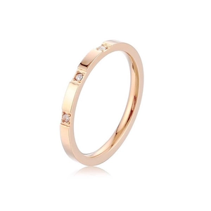 Minimalist rose gold titanium ring with three inset diamonds on a white background