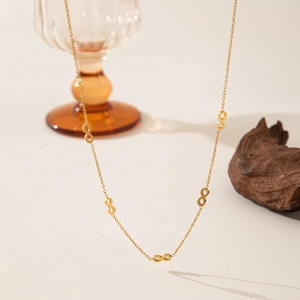 Elegant 18K gold plated stainless steel infinity symbol necklace for women on wooden stand