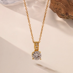 Elegant gold necklace with a large round cubic zirconia pendant on a delicate chain