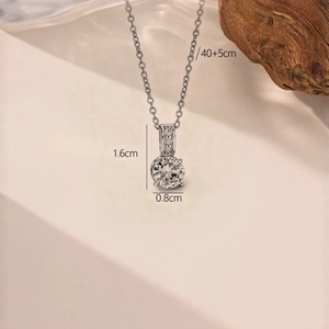 Elegant silver teardrop necklace with zircon stones on a classic O-chain and wood background