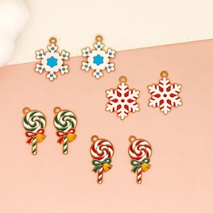 Detail view of festive Christmas enamel charms featuring snowflake and lollipop designs.