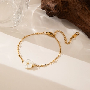 Elegant gold chain necklace featuring a white shell flower pendant with bead accents