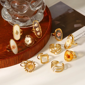 Detailed view of various vintage gold stainless steel rings with preserved flowers