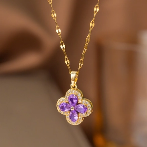 Luxurious gold four-leaf clover necklace with pear-shaped purple stones and micro-pave crystals