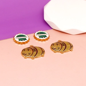 Close-up of beer festival alloy enamel charms featuring bottle cap and barrel designs