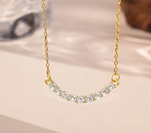 Macro shot of gold smile necklace pendant with 11 round cubic zirconia in claw setting