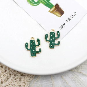 Close-up of green enamel cactus alloy charms for handmade DIY jewelry and craft projects