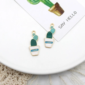 Close-up view of green cactus enamel charms with 'LOVE' pot detail for DIY jewelry making